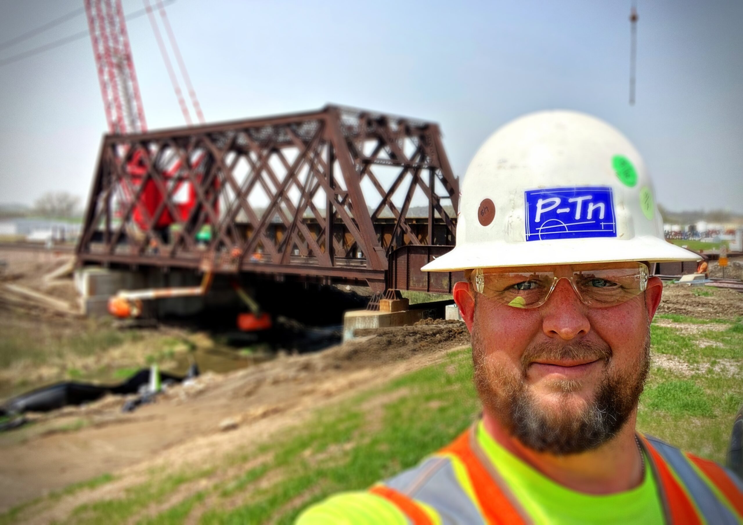 man wearing construction hat in front of a major railroad job construction site | P-Tn