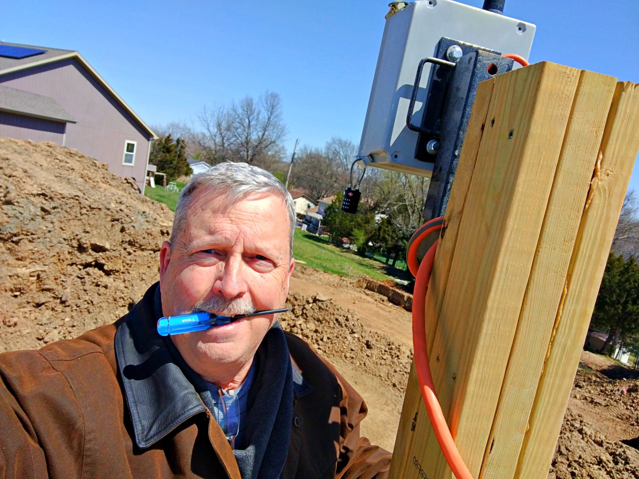 worker installs a webcam on a residential construction site | P-Tn