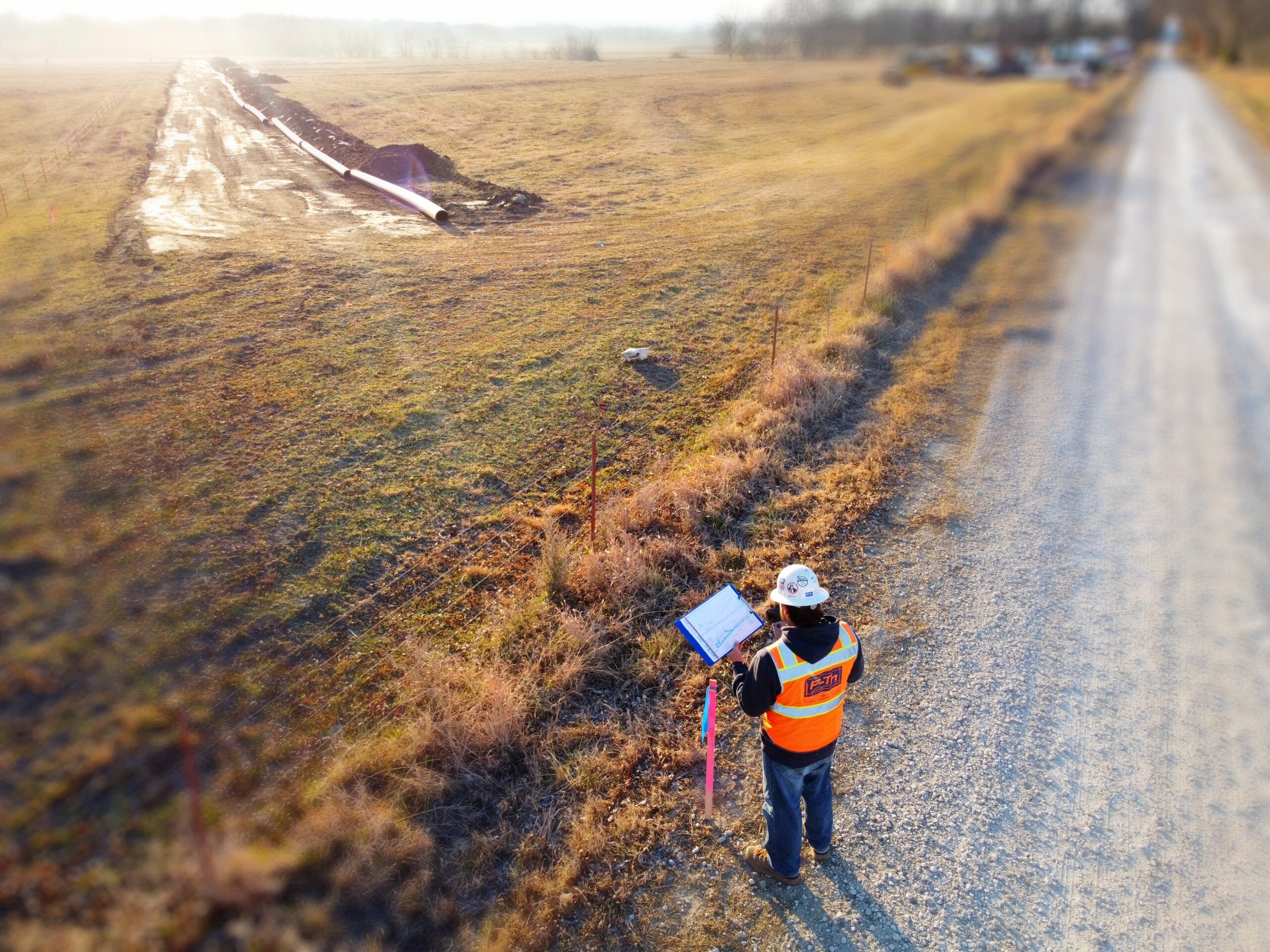 P-Tn professional photographer views plans for rural pipeline construction project. Independence, Kansas